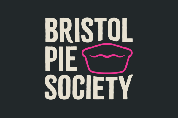 BPS LOGO OATMEAL HOT PINK ON SLATE GREY 600x400 - Those amazing pies are back from Bristol Pie Society